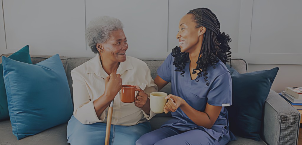 A care professional sitting with a resident, sharing a warm conversation